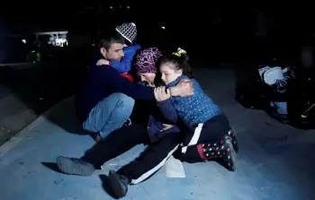 عائلة هرعت إلى الشارع بعد زلزال هاطاي (رويترز)