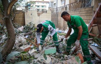فلسطينيون يتفقدون مبنى متضرر في غزة من قصف الاحتلال