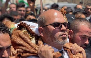 المحامي فريد الأطرش يحمل جثمان المعارض الذي اغتالته قوات أمن السلطة نزار بنات
