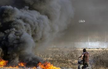 شاب يشعل النار في إطارات السيارات قرب السلك الحدودي الزائل شرق غزة