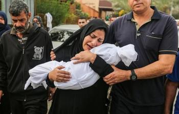 فلسطينية تحتض جثمان ابنها الرضيع قبل دفنه في أحد مقابر غزة