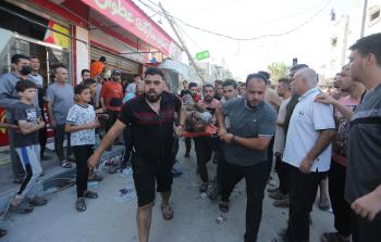 فلسطينيون يحملون على محفة أحد المصابين في غزة لى غزة