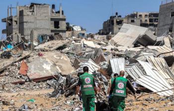 مسعفون ينتشلون أحد الشهداء وسط دمار كبير في المكان