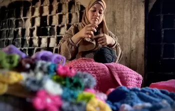 نساء نازحات يُعيدن تدوير الملابس لتدفئة الأطفال في غزة