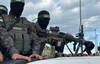 مقاتل من كتائب القسام يحمل بندقية إسرائيلية تتبع لجندي قتيل من لواء جولاني