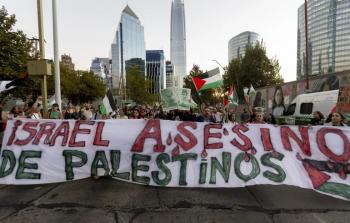 متظاهرون أمام السفارة الأميركية في سانتياغو يحملون لافتة تدين المجازر الإسرائيلية في قطاع غزة (الأناضول)