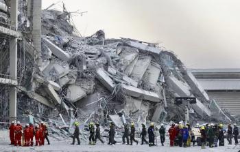 مشهد حي لفرق الإنقاذ أمام مبنى مدمر جرّاء الزلزال