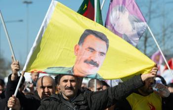 متظاهر يرفع صورة لزعيم جزب العمال الكردستاني أوجلان