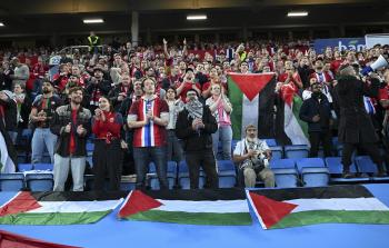 مشجعو المنتخب النرويجي على المدرجات ملعب أوليفال يرفعون أعلام النرويج وفلسطين