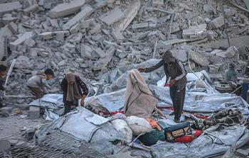 مواطنون يحاول انتشال ما يصلح استخدامه من تحت ركام منزلهم المدمر