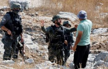 جنود من جيش الاحتلال يحاولون منع فلسطيني من الوصول إلى أرضه