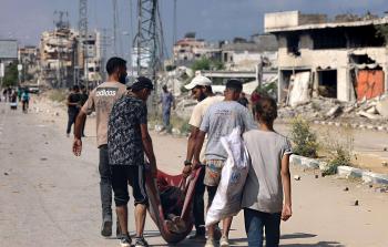 فلسطينيون يحملون جثمان شخص قُتل عند نقطة توزيع تديرها مؤسسة غزة الإنسانية (GHF)، على طريق صلاح الدين في النصيرات، وسط قطاع غزة، في 4 أغسطس/آب 2025