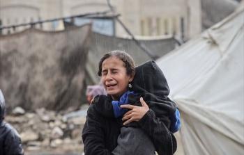 طفلة ترتجف بردًا وهي تحمل شقيقها الرضيع تحت الأمطار الغزيرة في غزة
