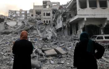 سيدتان من غزة تقفان أمام ركام منزل دمّره الاحتلال خلال الإبادة الجماعية على غزة