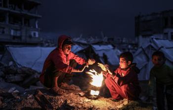 نازحون يحاول تدفئة أنفسهم بإشعال النار وسط منخفض جوي قاسٍ