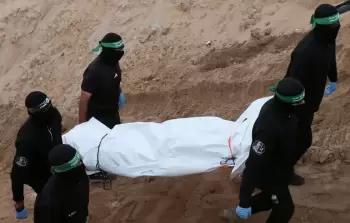 عناصر من المقاومة الفلسطينية في عملية سابقة لتسليم جثة أسير إسرائيلي في غزة