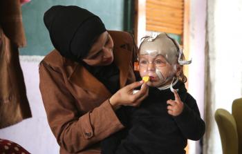 الطفل محمد حجيلة ووالدته في إحدى غرف مراكز الإيواء بمدينة غزة