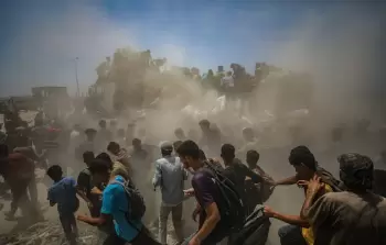 صورة من الأرشيف: نازحون فلسطينيون يحاولون انتزاع أكياس دقيق من شاحنة مساعدات في زيكيم شمال قطاع غزة (الأوربية)