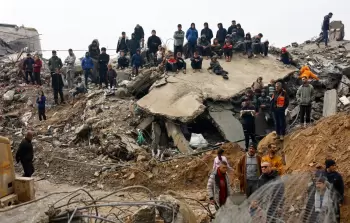 فلسطينيون خلال البحث عن ضحايا تحت أنقاض منزل انهار تحت المطر الغزير في بيت لاهيا شمال قطاع غزة (أرشيفية)