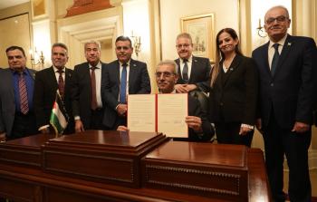 شعث مع عدد من أعضاء اللجنة خلال مراسم توقيع البيان الأول للجنة الوطنية لإدارة غزة