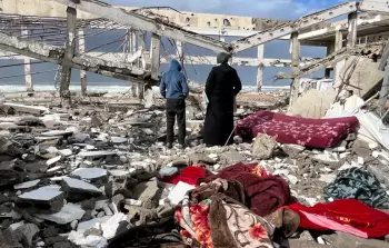 أقارب الضحايا الثلاثة من عائلة حمودة يتفقدون المكان بعد انهيار الجدار على الخيام بفعل الرياح الشديدة