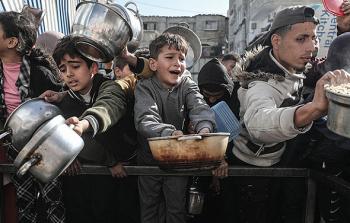 أطفال في غزة يحاولون الحصول على وجبة طعام من تكية