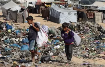 أطفال فلسطينيون يبحثون في القمامة بالقرب من مكب نفايات في قطاع غزة (تصوير: تامر قشطة)