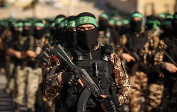 مقاومون من كتائب الشهيد عز الدين القسام يحملون أسلحتهم في غزة