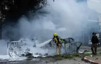 محاولة إخماد حريق اندلع في موقع سقوط شظايا صاروخ إيراني في 