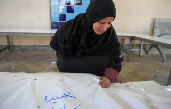 سيدة تودع أحد أفراد عائلتها الشهداء في غزة (أرشيفية)