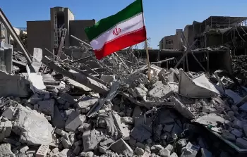 العلم الإيراني يرفرف فوق مبنى دمره العدوان الإسرائيلي الأمريكي