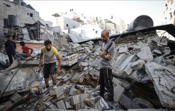 مواطنون يقفون فوق أنقاض منزل دمَّره الاحتلال بغزة (أرشيفية)