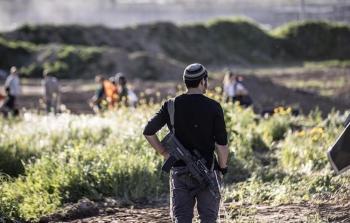 صورة من الأرشيف لمستوطن يحمل سلاحًا ضد الفلسطينيين في منازلهم وقراهم ومزارعهم بالضفة والقدس