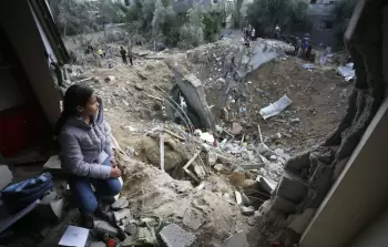 طفلة من غزة تجلس أمام الدمار الذي خلفه قصف الاحتلال لمنزلها (أرشيفية)