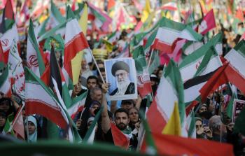 متظاهرون في إيران يملون العلمين الإيراني والفلسطيني