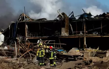 رجال الإطفاء يتفقدون منشأة صناعية تضررت جراء غارة صاروخية روسية في بلدة بروفاري بالعاصمة كييف