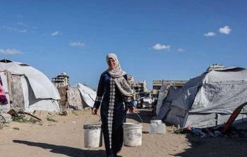 سيدة من غزة تحمل المياه في ظروف إنسانية قاسية