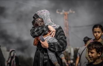 سيدة من غزة تحتضن طفلها تحت القصف والنزوح