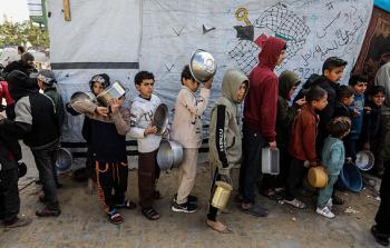 أطفال يقفون في طابور للحصول على طعام في غزة