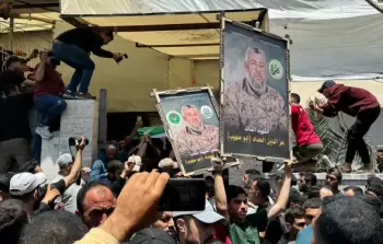 مواطنون يرفعون صورا للقائد الشهيد عز الدين الحداد