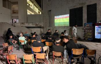 فلسطينيون من داخل أحد مراكز الإيواء يتابعون مجريات المونديال 2026