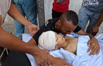 والد الطفل الشهيد عبد الرحمن بدوان يحضن جثمان نجله بعد استشهاده في حي الزيتون برصاص رشّاش آلي إسرائيلي مثبّت على رافعة شرقي مدينة غزة