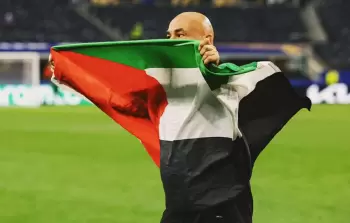مدرب المنتخب المصري حسام حسن يرفع العلم الفلسطيني بعد فوزه على أستراليا في كأس العالم