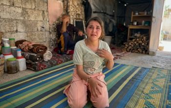 الطفلة وفي الخلف والدها المريض بسبب آثار سجنه لدى الاحتلال