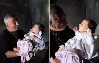 الرضيعة الناجية في حضن جدها.