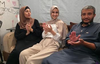 الطالبة نور محمد عودة تتوسط والديها