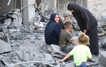 سيدة تجلس على ركام منزلها الذي دمرته طائرات الاحتلال الليلة الماضية (تصوير- محمود أبو حصيرة)