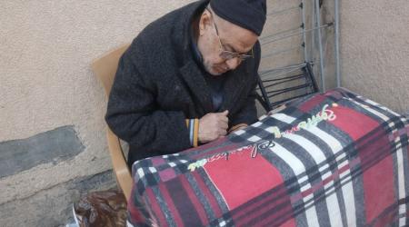 يجلس أبو تامر علي متكئًا على “الووكر” يراقب خطواته القليلة كما لو كانت إنجازًا يوميًا شاقًا