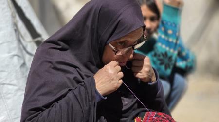 سُهيلا بني عيسى تتحدى النزوح بتطريز الفساتين التراثية (صور)