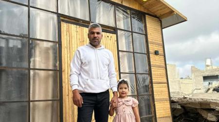 المواطن جودة وابنته يقفان بجوار منزلهما